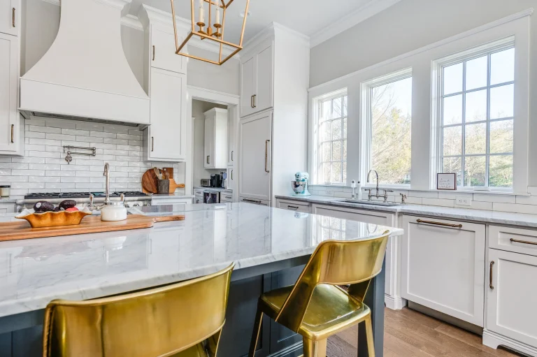 Home 18 A Kitchen With A Marble Island And Gold Chairs